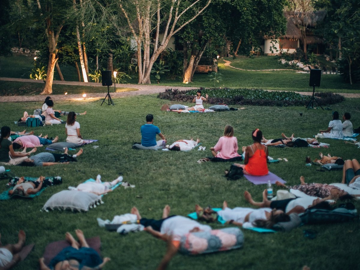 Personas recostadas en el pasto durante la meditación
