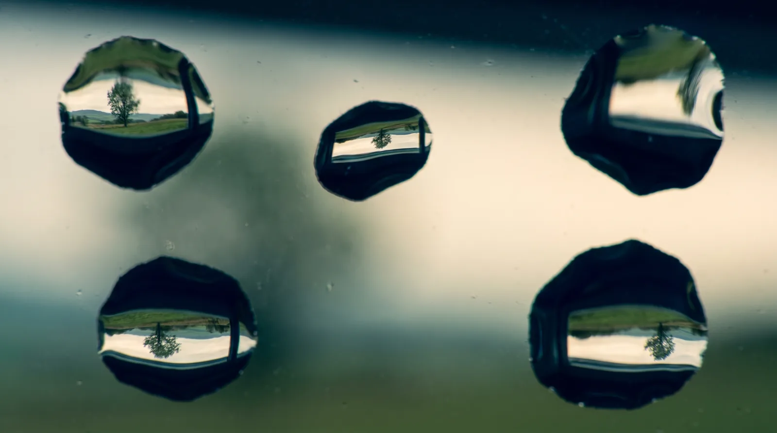 Gotas de lluvia en un vidrio: dentro de cada una el paisaje se ve n&iacute;tido y al rev&eacute;s